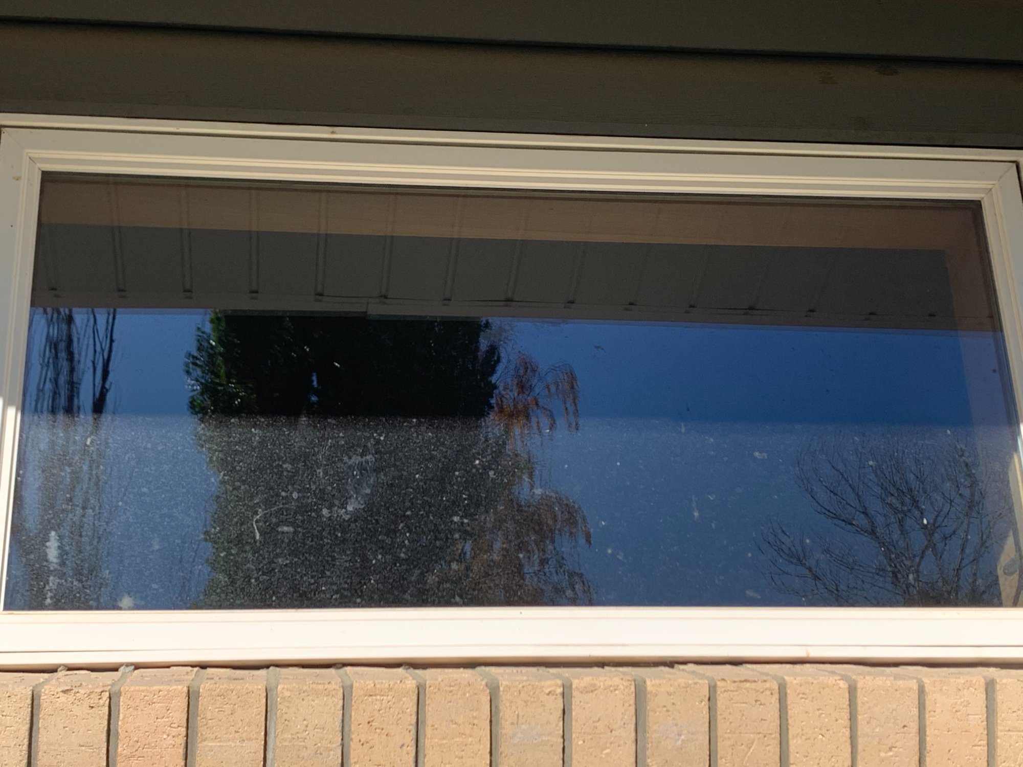 Before window washing Billings MT - hard water mineral stains on residential window